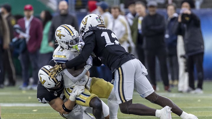 Dec 27, 2024; Birmingham, AL, USA;  Vanderbilt Commodores linebackers Nick Rinaldi (24) and Jeffrey Ugochukwu (12) stop Georgia Tech Yellow Jackets running back Jamal Haynes (11) during the first half of the 2024 Birmingham Bowl at Protective Stadium. Mandatory Credit: Vasha Hunt-Imagn Images