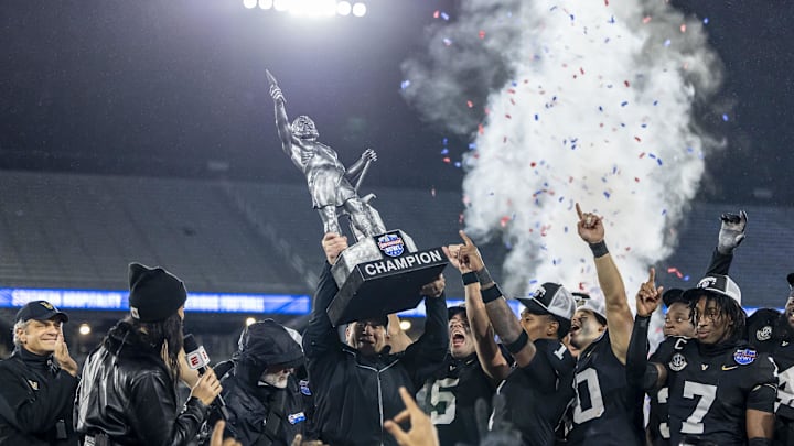 Dec 27, 2024; Birmingham, AL, USA;  Vanderbilt Commodores head coach Clark Lea hoists the bowl trophy after defeating the Georgia Tech Yellow Jackets in the 2024 Birmingham Bowl at Protective Stadium. Mandatory Credit: Vasha Hunt-Imagn Images