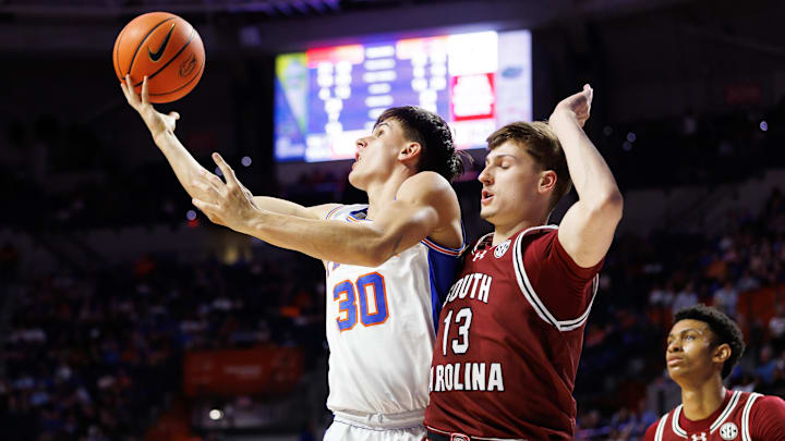 Feb 15, 2025; Gainesville, Florida, USA; Florida Gators guard Kajus Kublickas (30) attempts a layup over South Carolina Gamecocks guard Austin Herro (13) during the second half at Exactech Arena at the Stephen C. O'Connell Center. Mandatory Credit: Matt Pendleton-Imagn Images Feb 15, 2025; Gainesville, Florida, USA; Florida Gators guard Kajus Kublickas (30) attempts a layup over South Carolina Gamecocks guard Austin Herro (13) during the second half at Exactech Arena at the Stephen C. O'Connell Center. Mandatory Credit: Matt Pendleton-Imagn Images