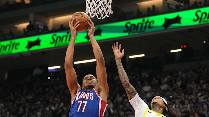 Nov 16, 2024; Sacramento, California, USA; Sacramento Kings center Orlando Robinson (77) rebounds against Utah Jazz guard Jordan Clarkson (00) during the first quarter at Golden 1 Center. Mandatory Credit: Darren Yamashita-Imagn Images