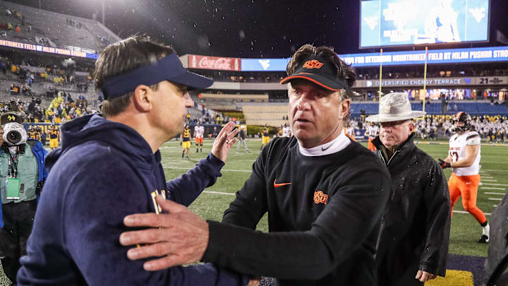 Oct 21, 2023; Morgantown, West Virginia, USA; Oklahoma State Cowboys head coach Mike Gundy talks with West Virginia Mountaineers head coach Neal Brown after the game at Mountaineer Field at Milan Puskar Stadium. Mandatory Credit: Ben Queen-Imagn Images