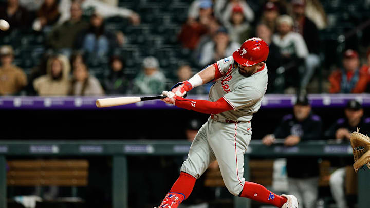 Philadelphia Phillies designated hitter Kyle Schwarber (12) hits a solo home run in the ninth inning against the Colorado Rockies at Coors Field.