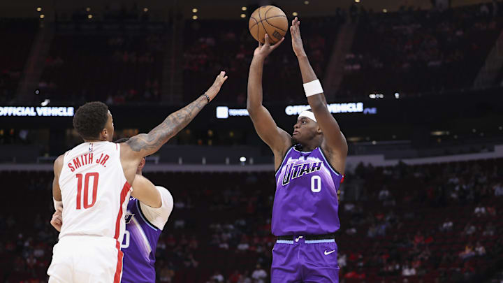 Oct 8, 2025; Houston, Texas, USA; Utah Jazz forward Taylor Hendricks (0) shoots the ball as Houston Rockets forward Jabari Smith Jr. (10) defends during the first quarter at Toyota Center. Mandatory Credit: Troy Taormina-Imagn Images