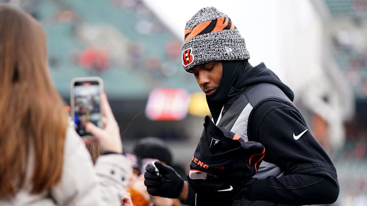 Cincinnati Bengals wide receiver Tee Higgins (5) signs autographs for fans during pregame warm ups