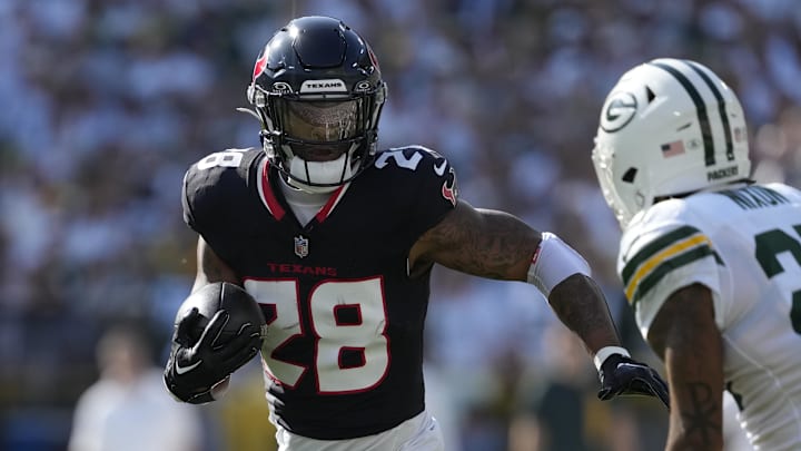 Oct 20, 2024; Green Bay, Wisconsin, USA;  Houston Texans running back Joe Mixon (28) rushes with the football against Green Bay Packers cornerback Keisean Nixon (25) during the first quarter at Lambeau Field. Mandatory Credit: Jeff Hanisch-Imagn Images