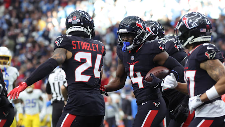Jan 11, 2025; Houston, Texas, USA; Houston Texans corner back Kamari Lassiter (4) celebrates an intercaption during the second quarter against the Los Angeles Chargers in an AFC wild card game at NRG Stadium. Mandatory Credit: Troy Taormina-Imagn Images
