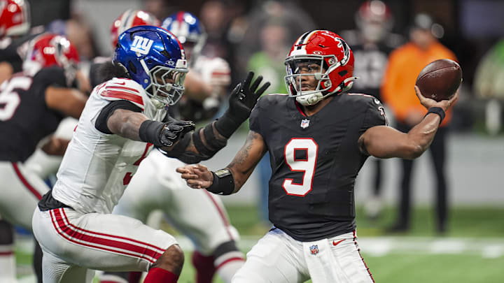 Dec 22, 2024; Atlanta, Georgia, USA; Atlanta Falcons quarterback Michael Penix Jr. (9) passes under pressure from New York Giants linebacker Kayvon Thibodeaux (5) during the first quarter at Mercedes-Benz Stadium. Mandatory Credit: Dale Zanine-Imagn Images