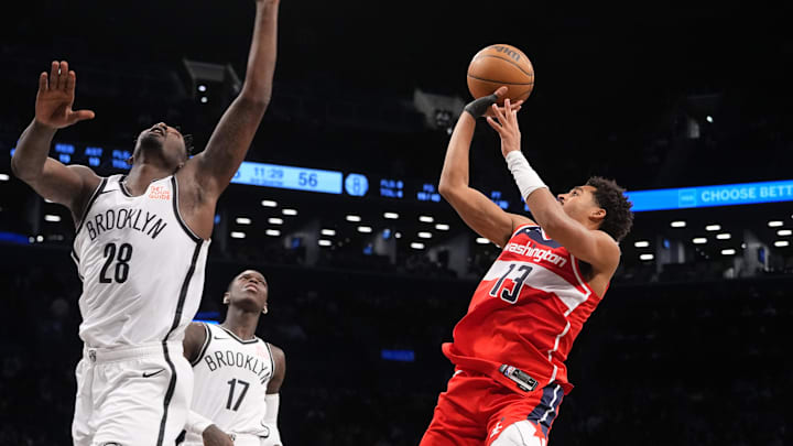 Oct 14, 2024; Brooklyn, New York, USA; Washington Wizards shooting guard Jordan Poole (13) shoots a jump shot against Brooklyn Nets power forward Dorian Finney-Smith (28) and Brooklyn Nets point guard Dennis Schroder (17) during the second half at Barclays Center. Mandatory Credit: Gregory Fisher-Imagn Images
