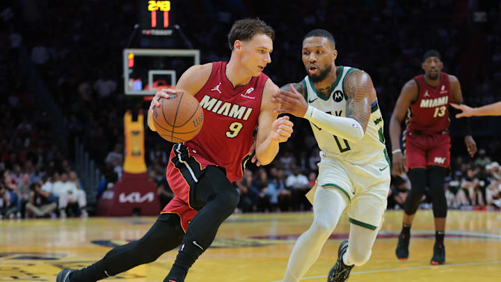 Nov 26, 2024; Miami, Florida, USA; Miami Heat guard Pelle Larsson (9) drives to the basket against Milwaukee Bucks guard Damian Lillard (0) during the second quarter at Kaseya Center. Mandatory Credit: Sam Navarro-Imagn Images