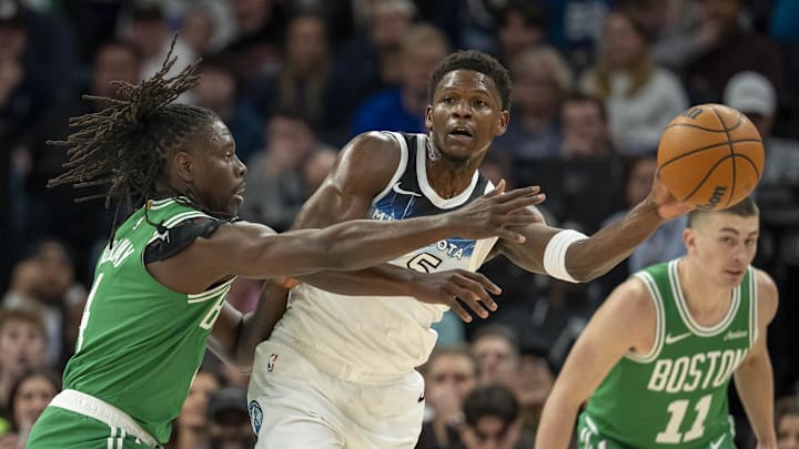 Jan 2, 2025; Minneapolis, Minnesota, USA; Minnesota Timberwolves guard Anthony Edwards (5) passes around Boston Celtics guard Jrue Holiday (4) in the first half at Target Center. Mandatory Credit: Jesse Johnson-Imagn Images
