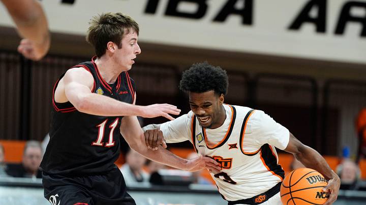 Oklahoma State Cowboys guard Jaylen Curry (0) dribbles beside Davidson Wildcats guard Sam Brown (11) during a first-round basketball game in the National Invitational between the Oklahoma State Cowboys and the Davidson Wildcats at Gallagher-Iba Arena in Stillwater, Okla., Tuesday, March 17, 2026.