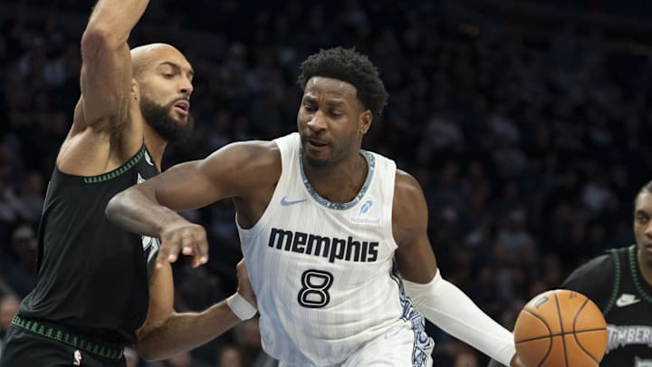 Dec 17, 2025; Minneapolis, Minnesota, USA; Memphis Grizzlies forward Jaren Jackson Jr. (8) dribbles the ball as Minnesota Timberwolves center Rudy Gobert (27) plays defense in the first half at Target Center. Mandatory Credit: Jesse Johnson-Imagn Images