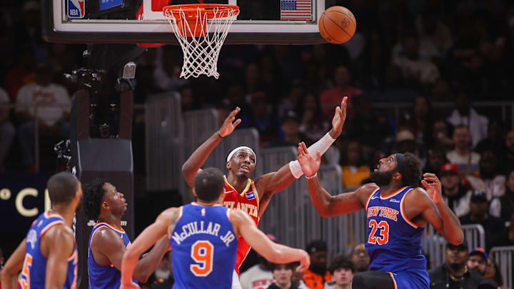 Dec 27, 2025; Atlanta, Georgia, USA; Atlanta Hawks forward Onyeka Okongwu (17) reaches for a rebound with New York Knicks center Mitchell Robinson (23) in the second quarter at State Farm Arena. Mandatory Credit: Brett Davis-Imagn Images