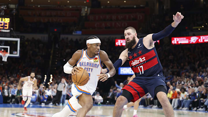 Dec 23, 2024; Oklahoma City, Oklahoma, USA; Oklahoma City Thunder guard Shai Gilgeous-Alexander (2) drives to the basket as Washington Wizards center Jonas Valanciunas (17) defends during the second half at Paycom Center. Mandatory Credit: Alonzo Adams-Imagn Images