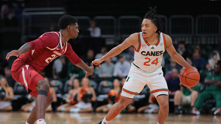 Dec 3, 2024; Coral Gables, Florida, USA; Miami Hurricanes guard Nijel Pack (24) dribblers the basketball as Arkansas Razorbacks forward Billy Richmond III (24) defends during the second half at Watsco Center. Mandatory Credit: Sam Navarro-Imagn Images