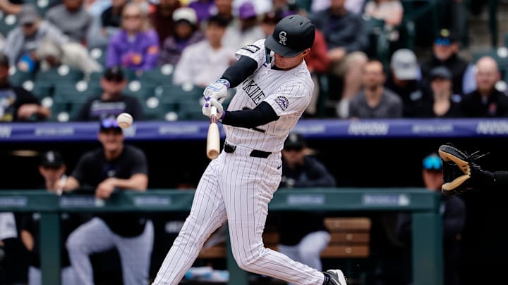 Apr 23, 2026; Denver, Colorado, USA; Colorado Rockies left fielder Mickey Moniak (22) hits a single in the second inning against the San Diego Padres at Coors Field. Mandatory Credit: Isaiah J. Downing-Imagn Images