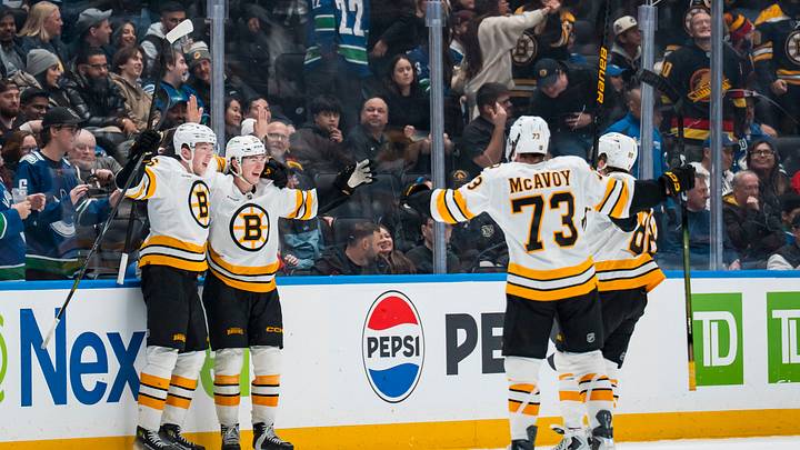 Jan 3, 2026; Vancouver, British Columbia, CAN; Boston Bruins forward Fraser Minten (93), defenseman Mason Lohrei (6), defenseman Charlie McAvoy (73) and forward David Pastrnak (88) celebrate Minten’s game winning goal against the Vancouver Canucks in overtime at Rogers Arena. Mandatory Credit: Bob Frid-Imagn Images