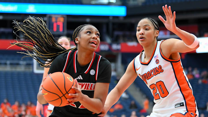 Feb 8, 2026; Syracuse, New York, USA; Louisville Cardinals guard Tajianna Roberts (22) drives against Syracuse Orange guard Dominique Darius (20) during the second half at the JMA Wireless Dome. Mandatory Credit: Rich Barnes-Imagn Images