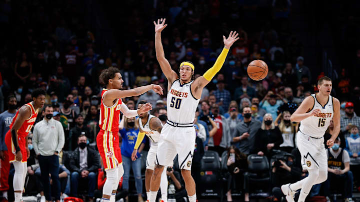 Nov 12, 2021; Denver, Colorado, USA; Atlanta Hawks guard Trae Young (11) passes the ball as Denver Nuggets forward Aaron Gordon (50) guards in the first quarter at Ball Arena. 