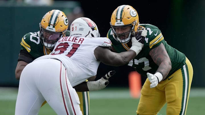 Green Bay Packers guard Zach Tom (50) and tackle Jordan Morgan (77) combine to block Cardinals defensive end L.J. Collier.