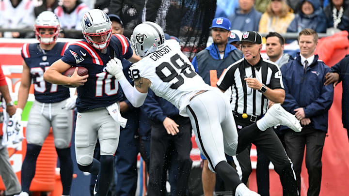Sep 7, 2025; Foxborough, Massachusetts, USA; New England Patriots quarterback Drake Maye (10) rushes the ball against Las Vegas Raiders defensive end Maxx Crosby (98) in the first half at Gillette Stadium. Mandatory Credit: Brian Fluharty-Imagn Images