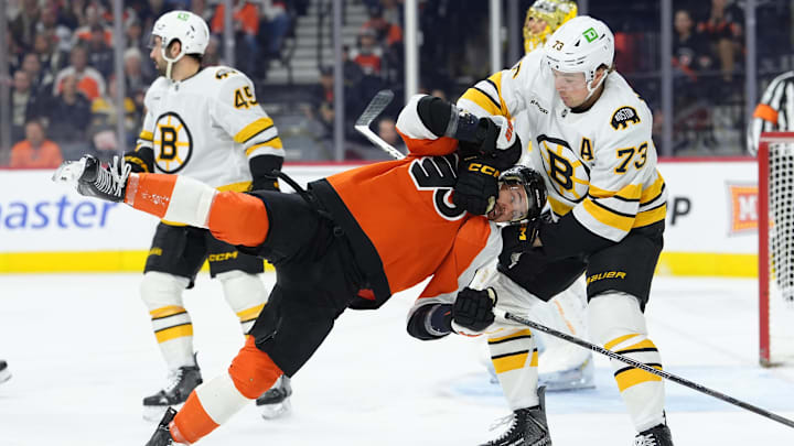 Apr 5, 2026; Philadelphia, Pennsylvania, USA; Boston Bruins defenseman Charlie McAvoy (73) grabs Philadelphia Flyers right wing Travis Konecny (11) in the first period at Xfinity Mobile Arena. Mandatory Credit: Kyle Ross-Imagn Images