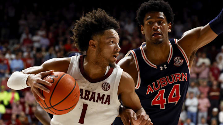 Jan 24, 2024; Tuscaloosa, Alabama, USA; Alabama Crimson Tide guard Mark Sears (1) dribbles around Auburn Tigers center Dylan Cardwell (44) on the way to the basket during the second half at Coleman Coliseum. Mandatory Credit: Butch Dill-Imagn Images
