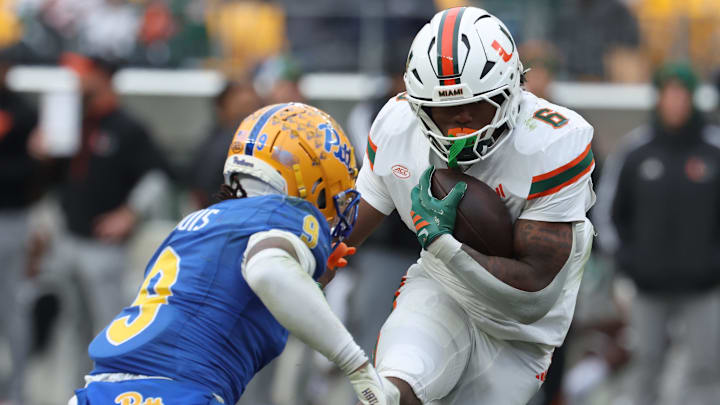 Nov 29, 2025; Pittsburgh, Pennsylvania, USA;  Miami Hurricanes running back CharMar Brown (6) runs the ball as Pittsburgh Panthers linebacker Kyle Louis (9) defends during the fourth quarter at Acrisure Stadium. Mandatory Credit: Charles LeClaire-Imagn Images