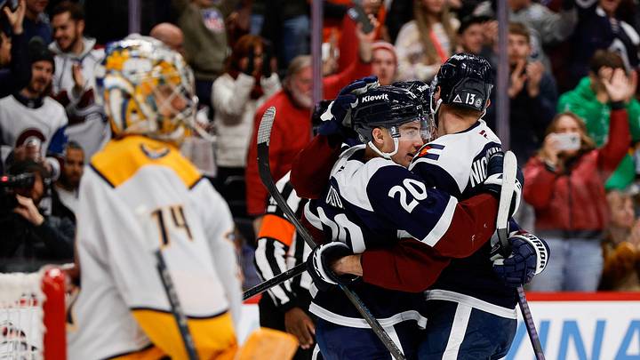 Dec 14, 2024; Denver, Colorado, USA; Colorado Avalanche center Ross Colton (20) celebrates his goal with right wing Valeri Nichushkin (13) as Nashville Predators goaltender Juuse Saros (74) looks on in the second period at Ball Arena. Mandatory Credit: Isaiah J. Downing-Imagn Images