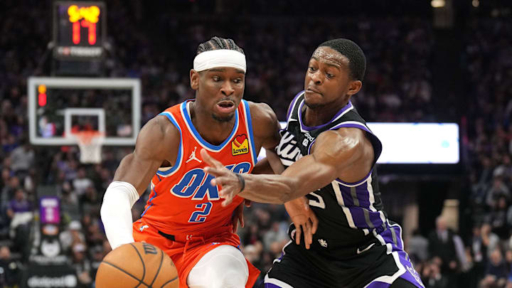 Dec 14, 2023; Sacramento, California, USA; Oklahoma City Thunder guard Shai Gilgeous-Alexander (2) dribbles against Sacramento Kings guard De'Aaron Fox (right) during the fourth quarter at Golden 1 Center. Mandatory Credit: Darren Yamashita-Imagn Images