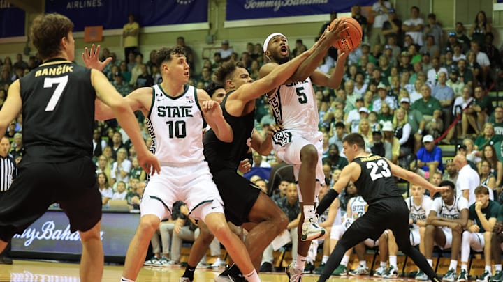 Nov 25, 2024; Lahaina, Hawaii, USA;  Colorado Buffaloes center Elijah Malone (50) tries to prevent Michigan State Spartans guard Tre Holloman (5) from scoring in the second half of an NCAA college basketball game at Lahaina Civic Center. Mandatory Credit: Marco Garcia-Imagn Images