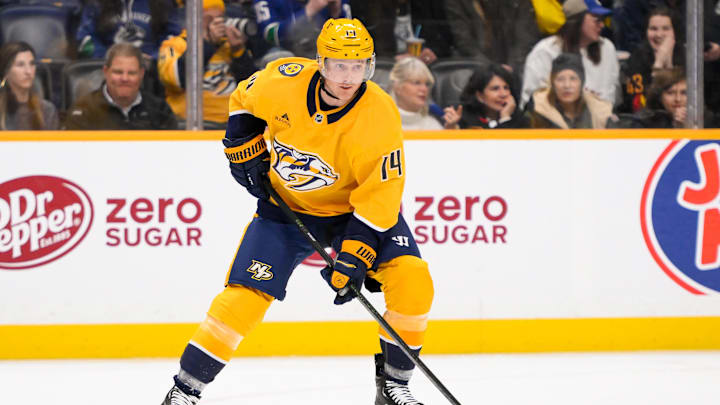 Jan 29, 2025; Nashville, Tennessee, USA;  Nashville Predators center Gustav Nyquist (14) skates with the puck against the Vancouver Canucks during the first period at Bridgestone Arena. Mandatory Credit: Steve Roberts-Imagn Images