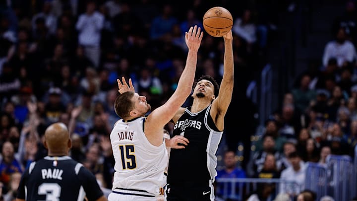 Denver Nuggets center Jokic and San Antonio Spurs center Wembanyama battle for the ball.