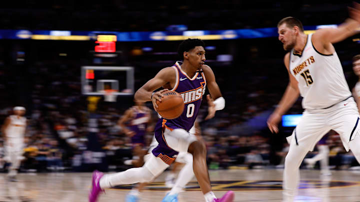 Oct 13, 2024; Denver, Colorado, USA; Phoenix Suns forward Ryan Dunn (0) controls the ball as Denver Nuggets center Nikola Jokic (15) defends in the second quarter at Ball Arena. Mandatory Credit: Isaiah J. Downing-Imagn Images