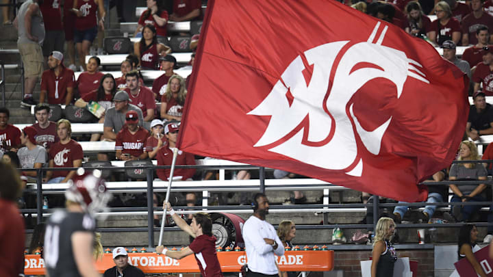 Sep 7, 2024; Pullman, Washington, USA; Washington State Cougars cheerleader carries the school flag against the Texas Tech Red Raiders in the second half at Gesa Field at Martin Stadium. Washington State Cougars won 37-16. Mandatory Credit: James Snook-Imagn Images