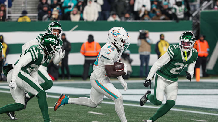 Jan 5, 2025; East Rutherford, New Jersey, USA; Miami Dolphins running back De'Von Achane (28) scores a rushing touchdown during the second half as New York Jets safety Ashtyn Davis (21) pursues at MetLife Stadium. Mandatory Credit: Vincent Carchietta-Imagn Images