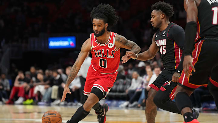 Feb 1, 2026; Miami, Florida, USA;  Chicago Bulls guard Coby White (0) drives to the basket as Miami Heat guard Davion Mitchell (45) follows on the play during the first half at Kaseya Center. Mandatory Credit: Jim Rassol-Imagn Images