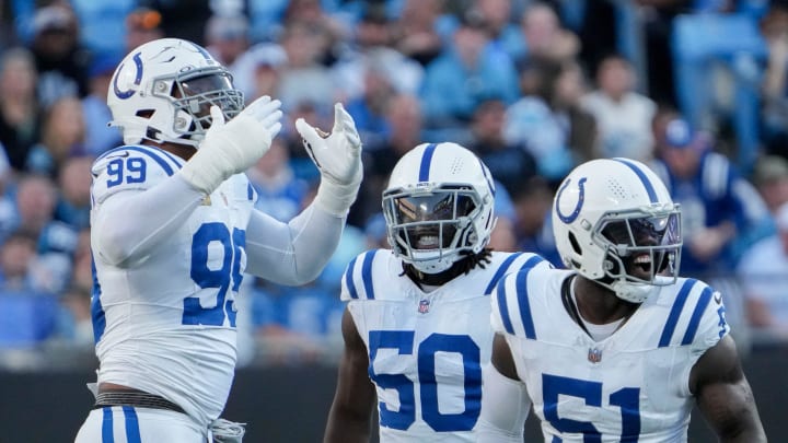 Indianapolis Colts defensive tackle DeForest Buckner (99) blows kisses to the crowd as linebacker Segun Olubi (50) and defensive end Kwity Paye (51) celebrate a sack during a game against the Carolina Panthers at Bank of America Stadium.