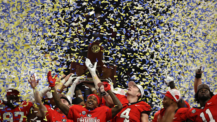 Dec 7, 2024; Atlanta, GA, USA; The Georgia Bulldogs celebrate with the trophy after defeating the Texas Longhorns in overtime in the 2024 SEC Championship game at Mercedes-Benz Stadium.