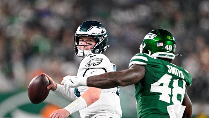 Aug 22, 2025; East Rutherford, New Jersey, USA; Philadelphia Eagles quarterback Kyle McCord (19) looks to pass the ball chased by New York Jets linebacker Boog Smith (48) during the third quarter at MetLife Stadium. Mandatory Credit: Mark Smith-Imagn Images