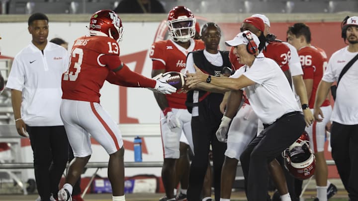 Houston Cougars defensive back C.J. Douglas (13) hands the ball to head coach Willie Fritz after an interception during the fourth quarter against the Stephen F. Austin Lumberjacks at TDECU Stadium. Houston Cougars defensive back C.J. Douglas (13) hands the ball to head coach Willie Fritz after an interception during the fourth quarter against the Stephen F. Austin Lumberjacks at TDECU Stadium.