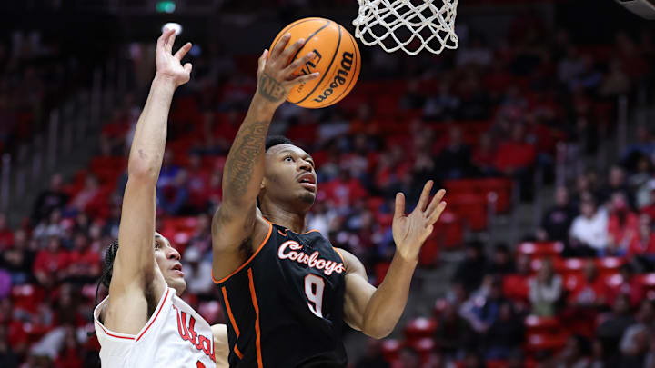 Jan 31, 2026; Salt Lake City, Utah, USA; Oklahoma State Cowboys guard Anthony Roy (9) lays the ball up against Utah Utes forward Keanu Dawes (8) during the first half at Jon M. Huntsman Center. Mandatory Credit: Rob Gray-Imagn Images