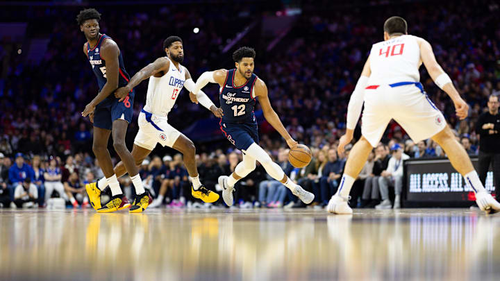 Mar 27, 2024; Philadelphia, Pennsylvania, USA; Philadelphia 76ers forward Tobias Harris (12) dribbles past LA Clippers forward Paul George (13): Bill Streicher-Imagn Images