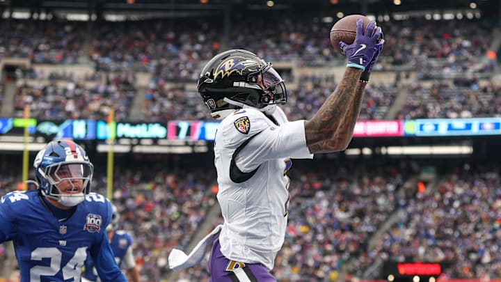 Dec 15, 2024; East Rutherford, New Jersey, USA; Baltimore Ravens wide receiver Rashod Bateman (7) catches a touchdown pass in front of New York Giants safety Dane Belton (24) during the first half at MetLife Stadium. Mandatory Credit: Vincent Carchietta-Imagn Images
