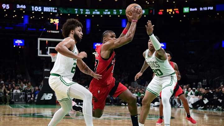 Oct 13, 2024; Boston, Massachusetts, USA;  Toronto Raptors guard Jahmi'us Ramsey (37) goes to the basket between Boston Celtics forward Anton Watson (28) and guard JD Davison (20) during the second half at TD Garden. Mandatory Credit: Bob DeChiara-Imagn Images