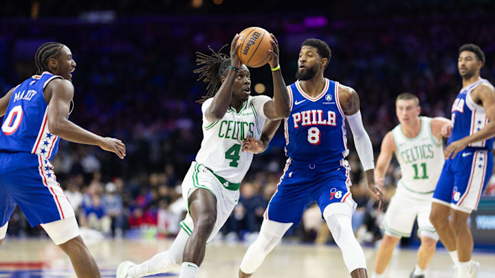 Feb 20, 2025; Philadelphia, Pennsylvania, USA; Boston Celtics guard Jrue Holiday (4) drives against Philadelphia 76ers forward Paul George (8) during the second quarter at Wells Fargo Center. Mandatory Credit: Bill Streicher-Imagn Images