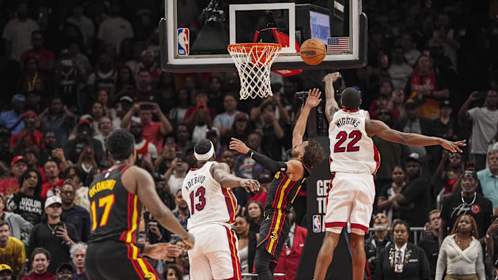 Apr 18, 2025; Atlanta, Georgia, USA; Atlanta Hawks guard Trae Young (11) ties the game in the final seconds behind Miami Heat forward Andrew Wiggins (22) during the second half at State Farm Arena. Mandatory Credit: Dale Zanine-Imagn Images