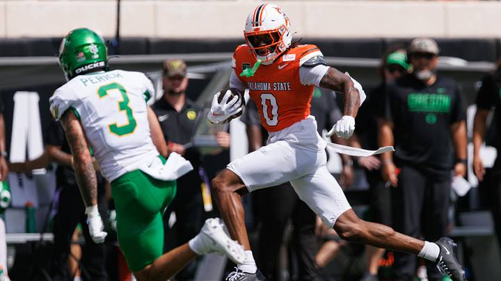 Sep 12, 2026; Stillwater, Oklahoma, USA;  Oklahoma State Cowboys wide receiver Justin Bowick (0) runs with the ball as Oregon Ducks defensive back Koi Perich (3) defends during the first quarter at Boone Pickens Stadium.  Mandatory Credit: William Purnell-Imagn Images
