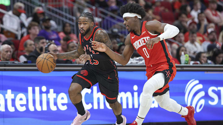 Feb 9, 2025; Houston, Texas, USA; Toronto Raptors guard Jamal Shead (23) drives with the ball as Houston Rockets guard Aaron Holiday (0) defends during the second quarter at Toyota Center. Mandatory Credit: Troy Taormina-Imagn Images