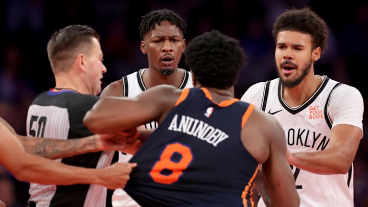 Nov 15, 2024; New York, New York, USA; New York Knicks forward OG Anunoby (8) is separated from Brooklyn Nets forward Dorian Finney-Smith (28) by referee Gediminas Petraitis (50) and Nets forward Cameron Johnson (2) during the fourth quarter at Madison Square Garden. Mandatory Credit: Brad Penner-Imagn Images